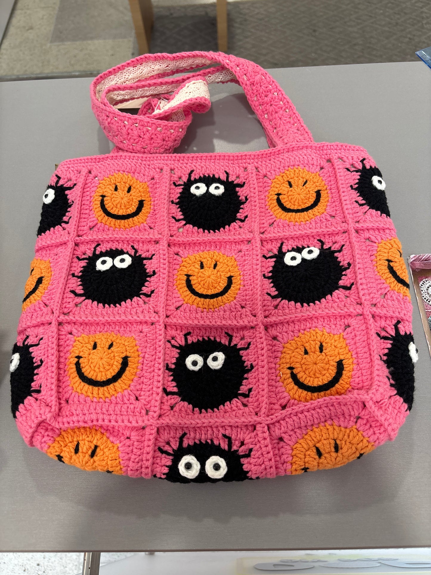 handmade crochet bag with a stylish smile face